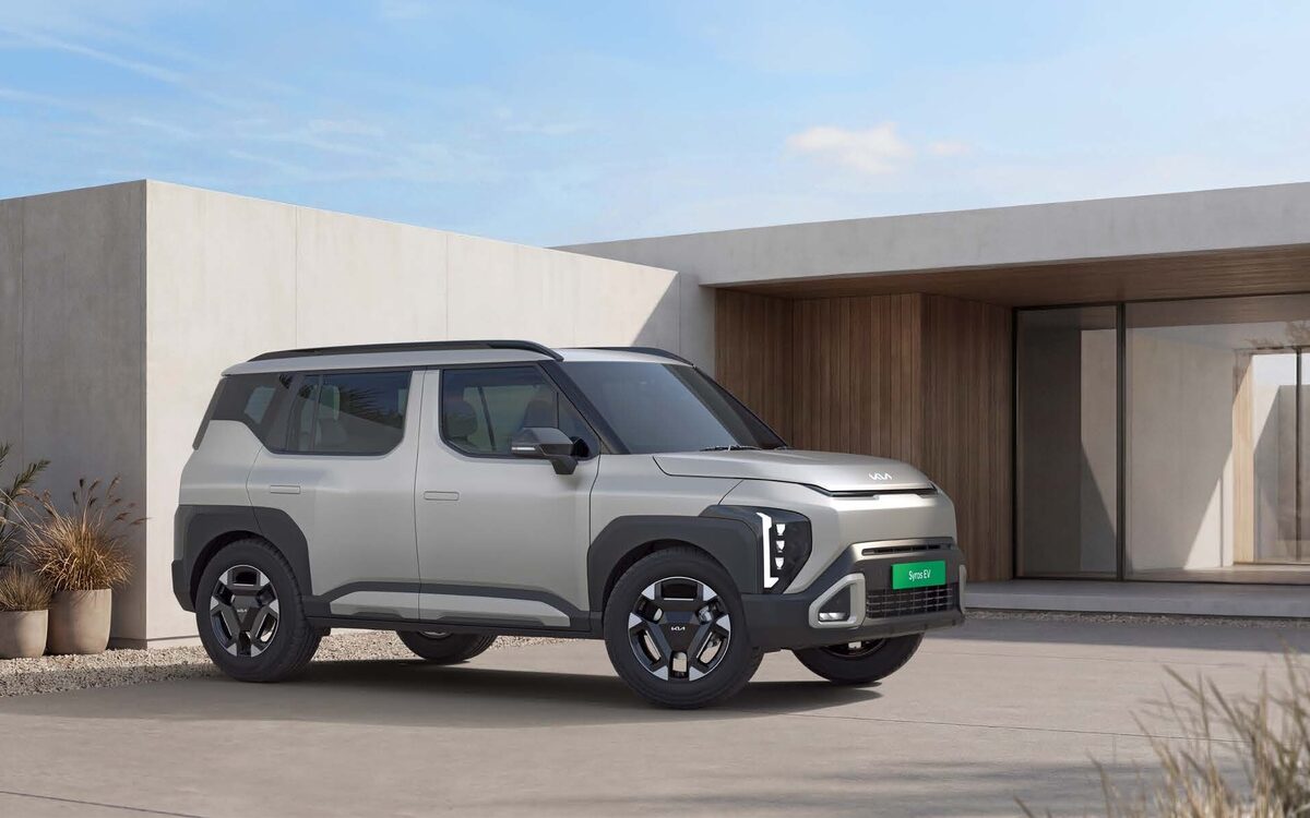 Kia Syros EV in silver parked in front of a modern house, front three-quarter view