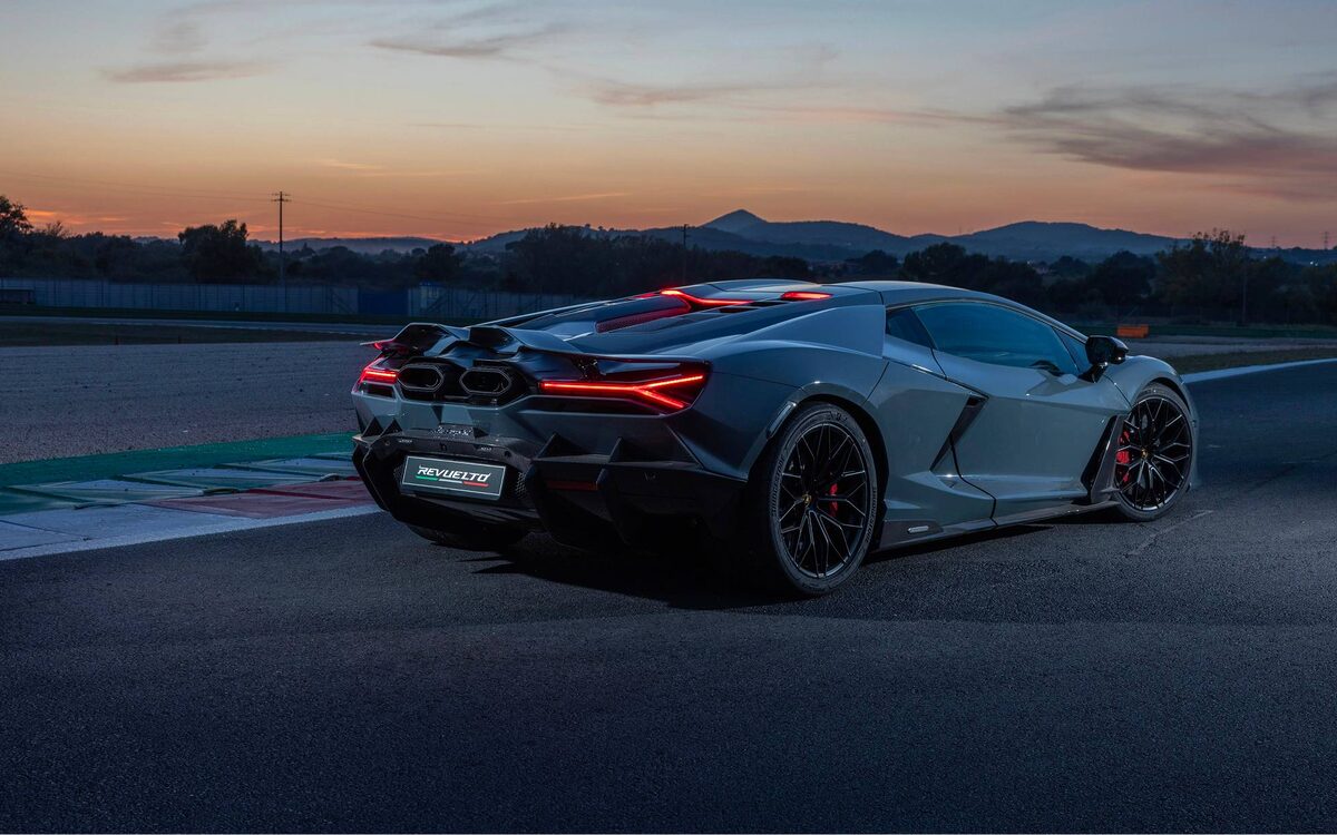Lamborghini Revuelto in grey, rear three-quarter view on a race track at dusk