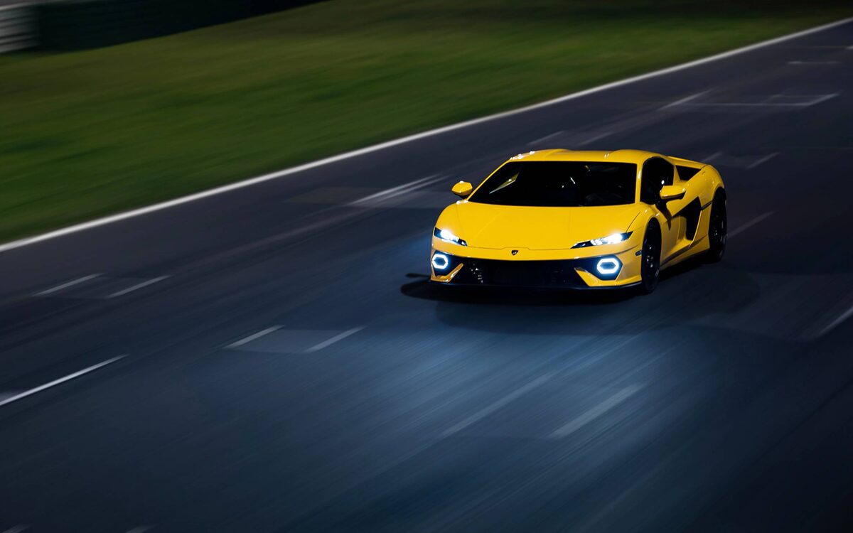 Lamborghini Temerario in yellow driving fast on a track, front view with motion blur