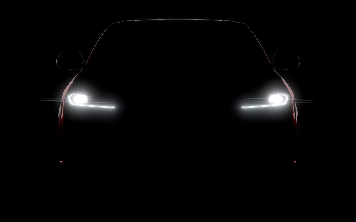 Lamborghini Urus SE front of the car in darkness with only the two headlamps lit
