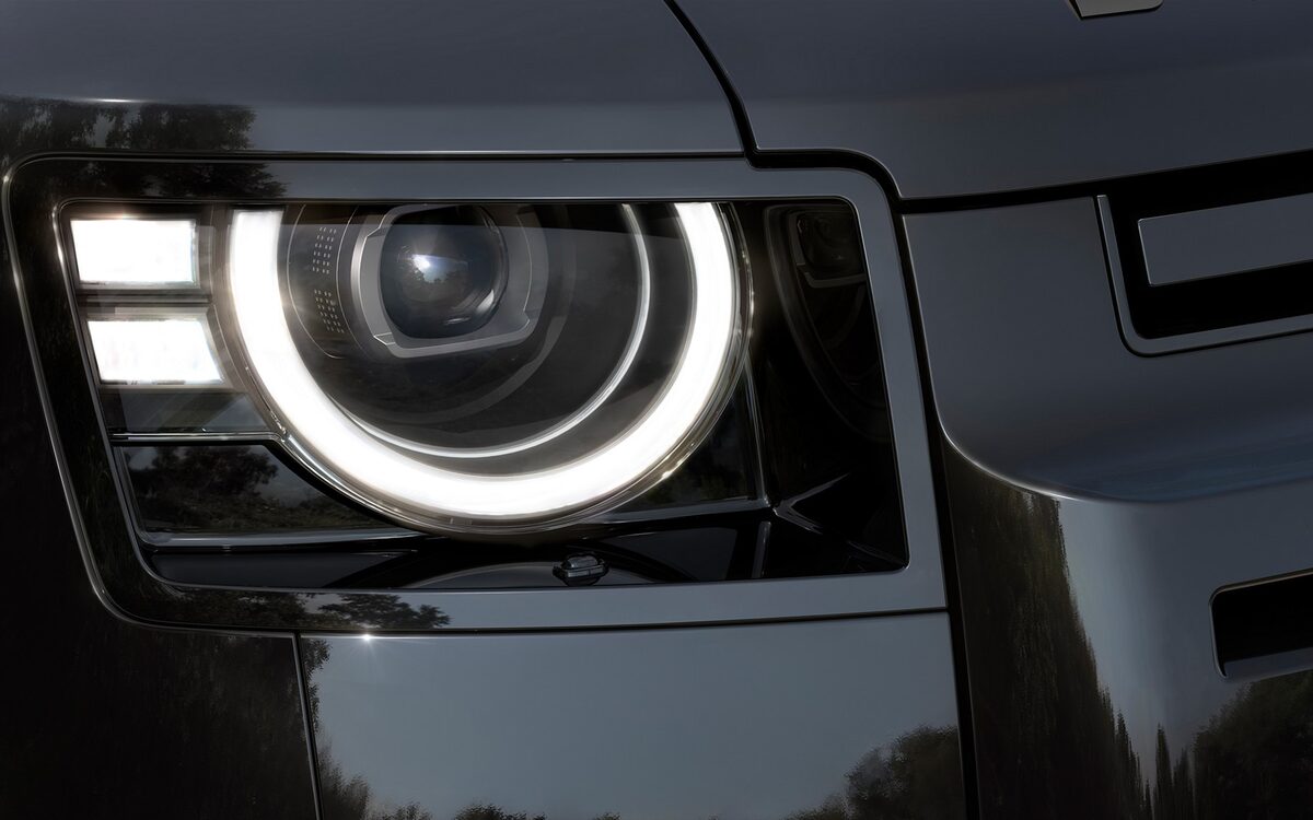Close-up of the Land Rover Defender round LED headlamp with signature DRL
