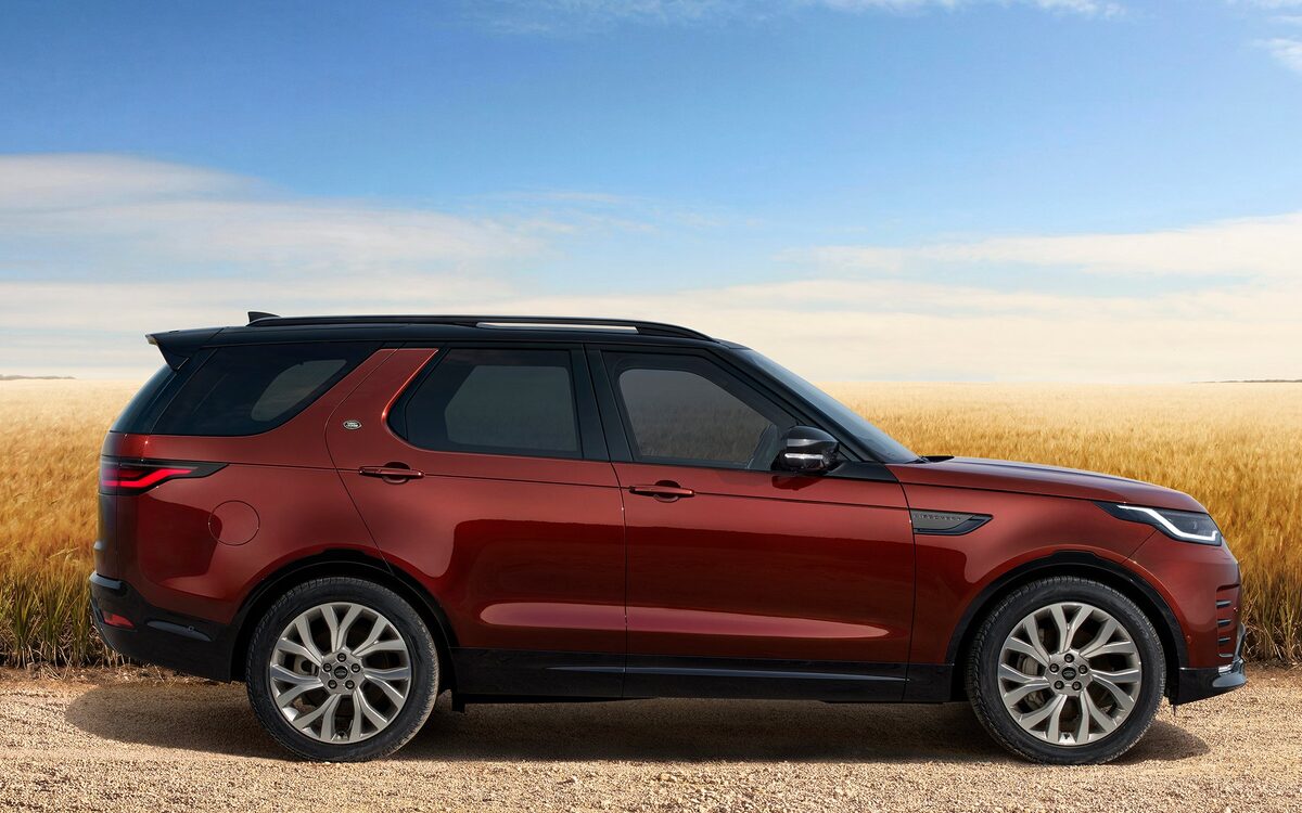 Land Rover Discovery in red, side profile in a wheat field