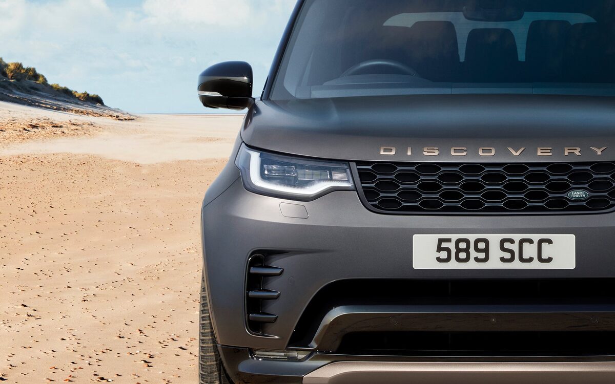 Close-up of the Land Rover Discovery front end with headlamp, grille and bonnet lettering