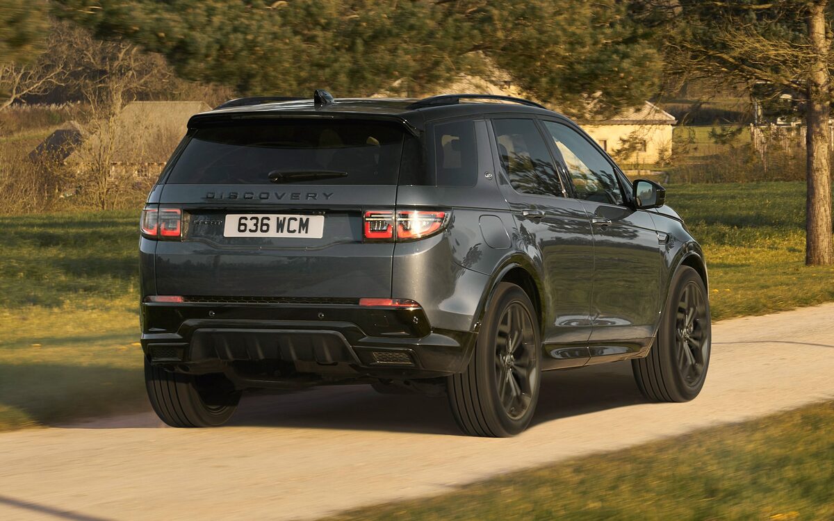 Land Rover Discovery Sport in grey, rear three-quarter view on a country lane