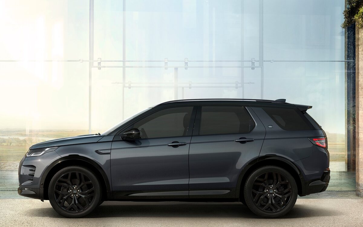 Land Rover Discovery Sport in grey, side profile in front of a glass wall