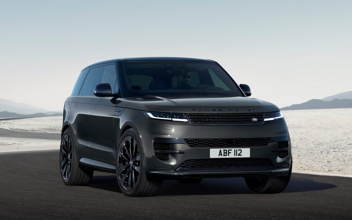 Range Rover Sport in dark grey on a curving desert road, seen from the front