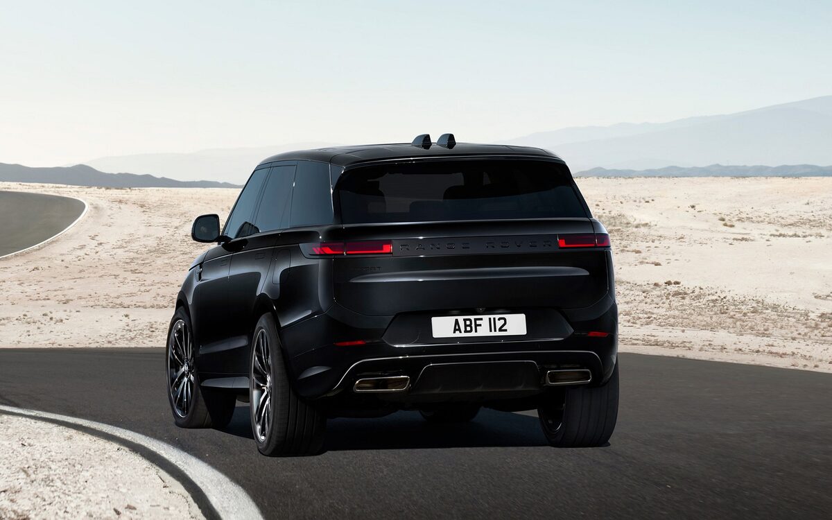 Range Rover Sport in black on a desert road, rear three-quarter view