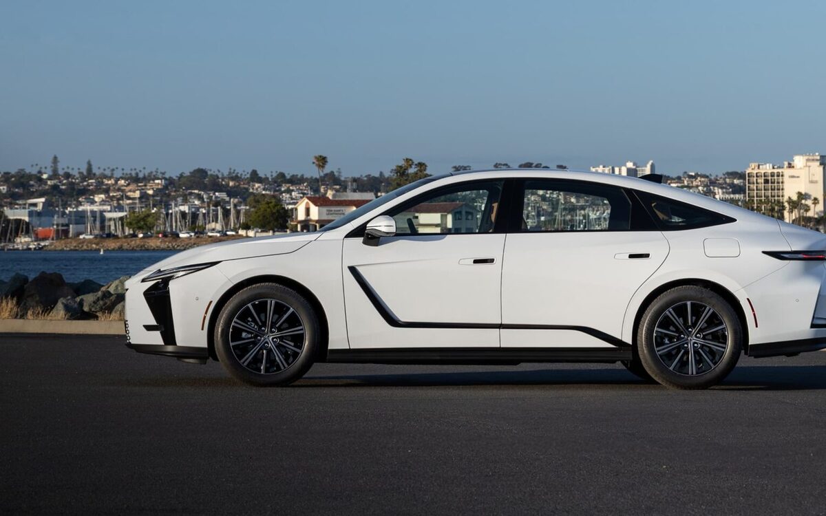 Side profile of a white Lexus ES 350h on a harbour-side road