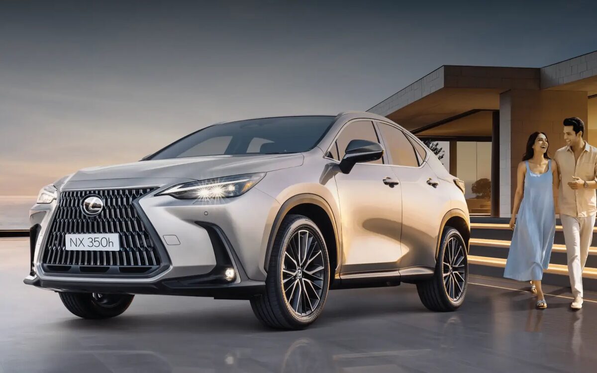 Lexus NX 350h parked outside a modern house at dusk with a couple walking past