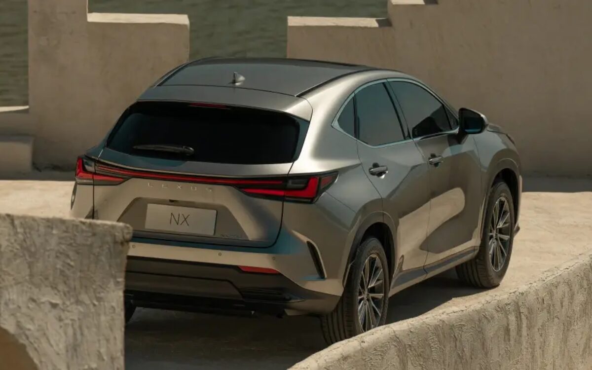 Lexus NX seen from the rear three-quarter showing the full-width tail lamp and tailgate