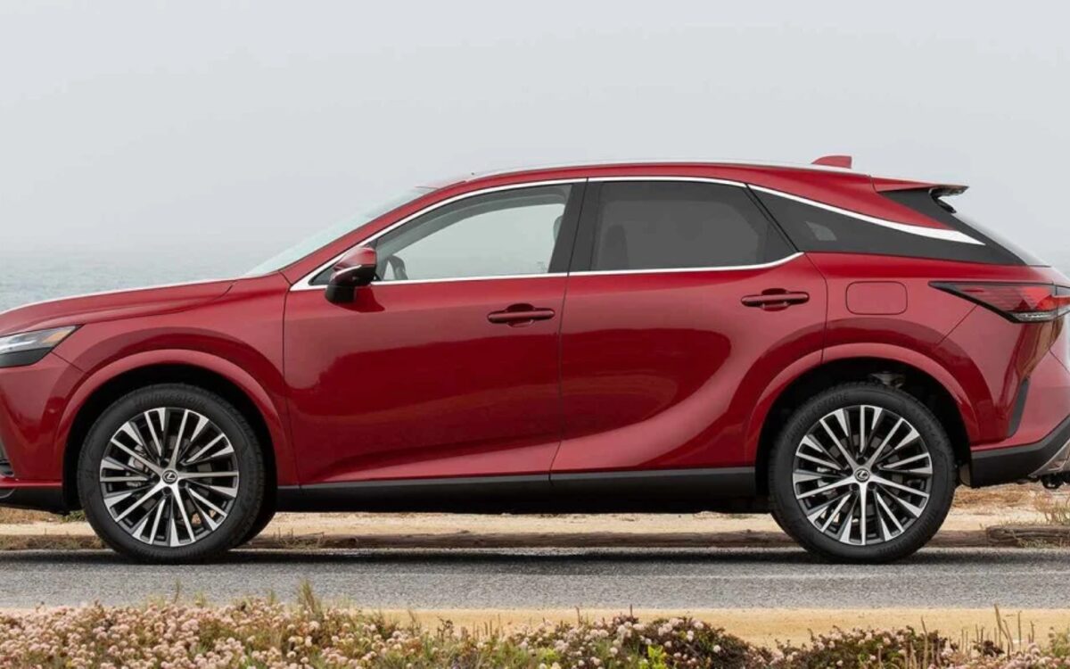 Side profile of a red Lexus RX 350h on a coastal road