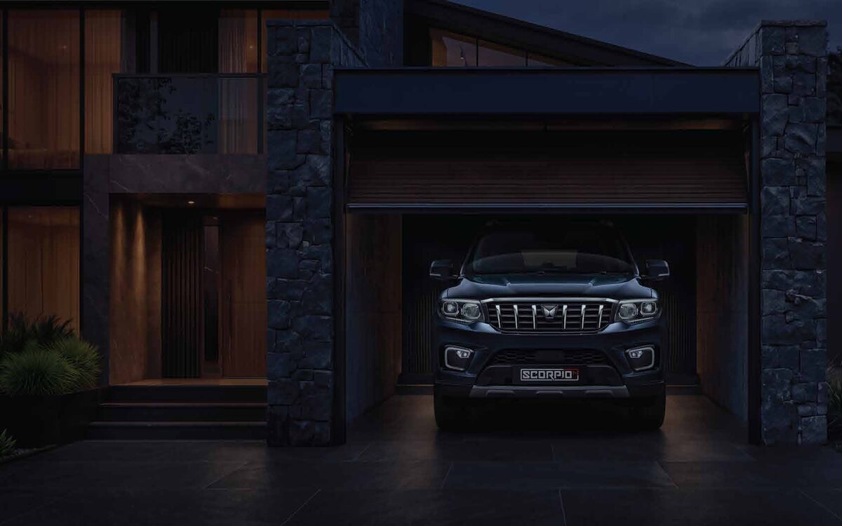 Mahindra Scorpio N facing the camera in a dimly lit garage at dusk