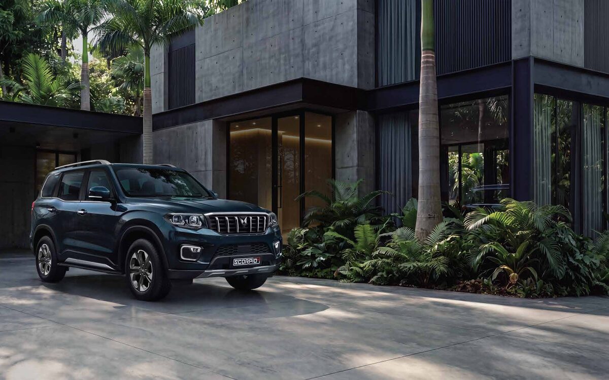 Mahindra Scorpio N in a dark colour on a villa driveway with palm trees