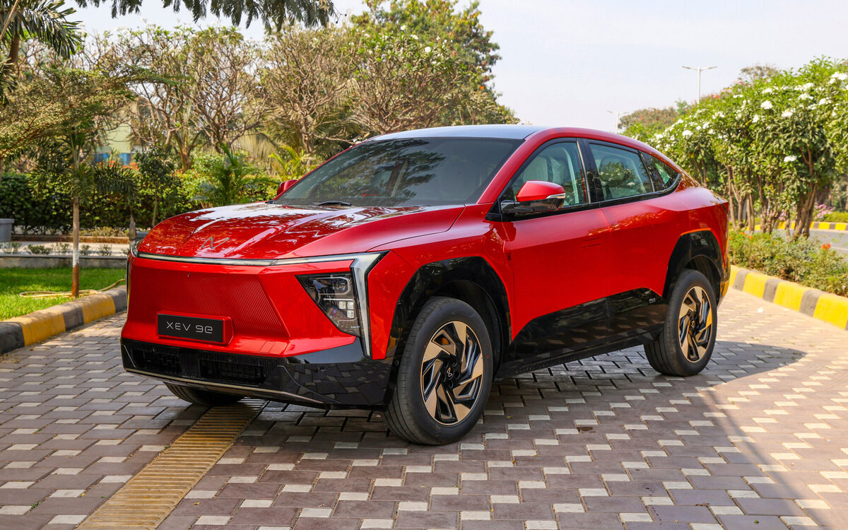 Mahindra XEV 9e in Tango Red, front three-quarter view parked on a paved road