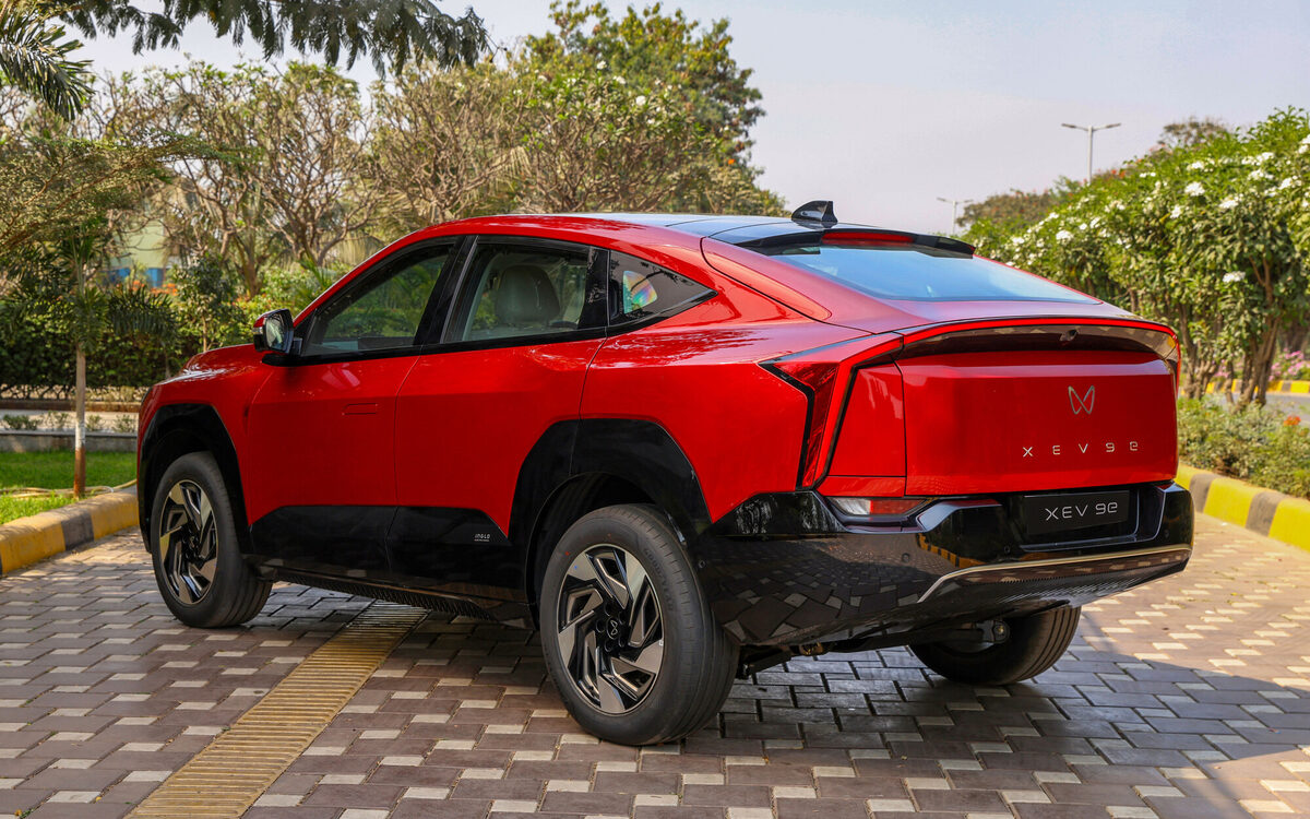 Mahindra XEV 9e in Tango Red, rear three-quarter view with the full-width tail lamp