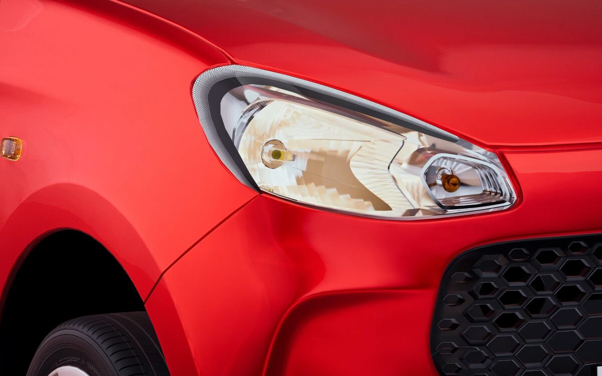 Close-up of the Alto K10 headlamp on a red front fender