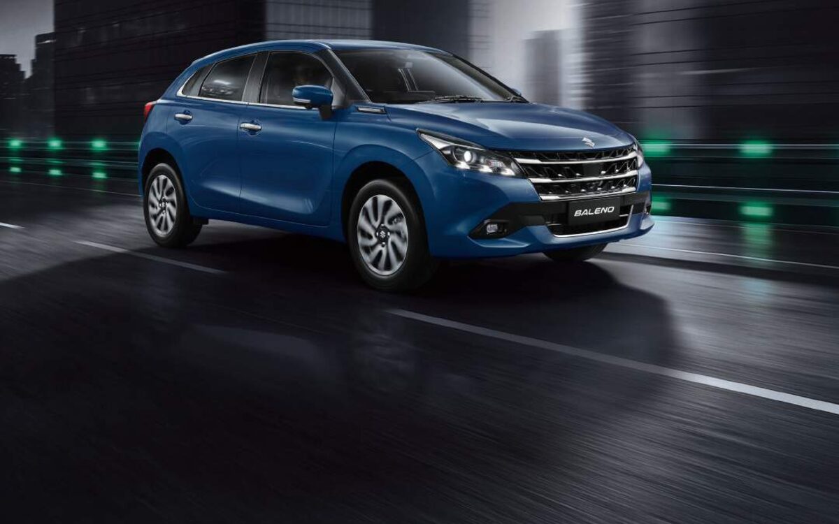 Baleno in blue driving on a dark city road at dusk