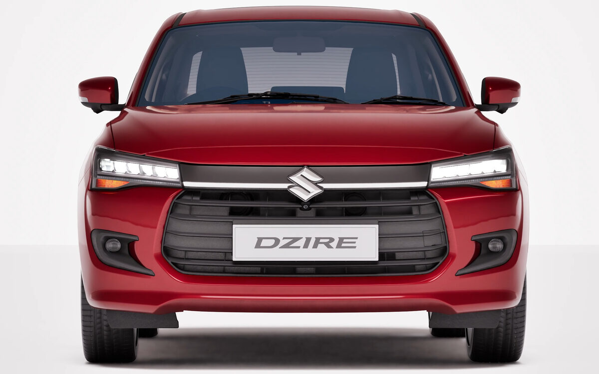 Dzire in red, straight-on front view in a white studio