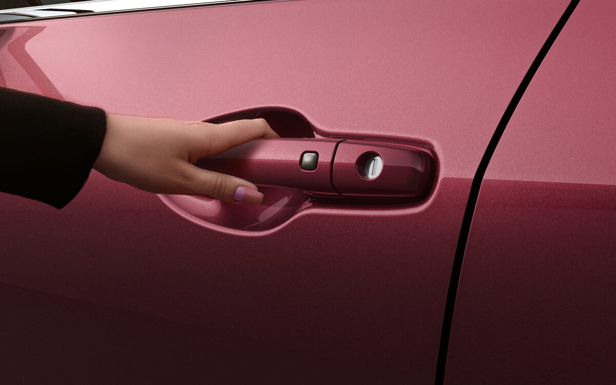 A hand pulling the Dzire's door handle