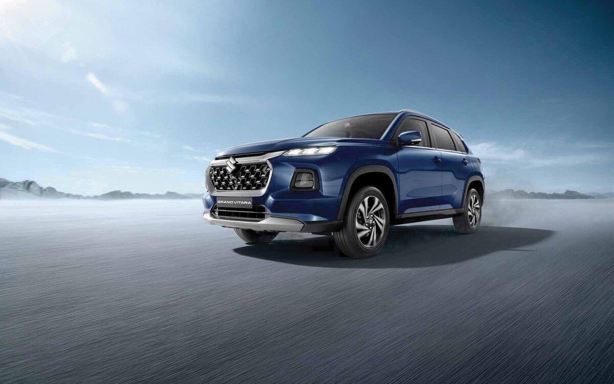 Maruti Suzuki Grand Vitara in Nexa Blue, front three-quarter view on an open road