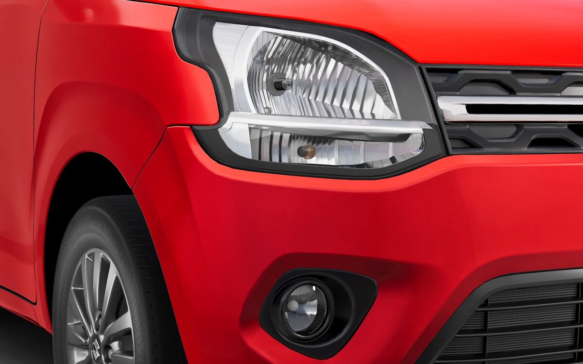 Close-up of the Wagon R's front headlamp, grille and fog lamp on a red body
