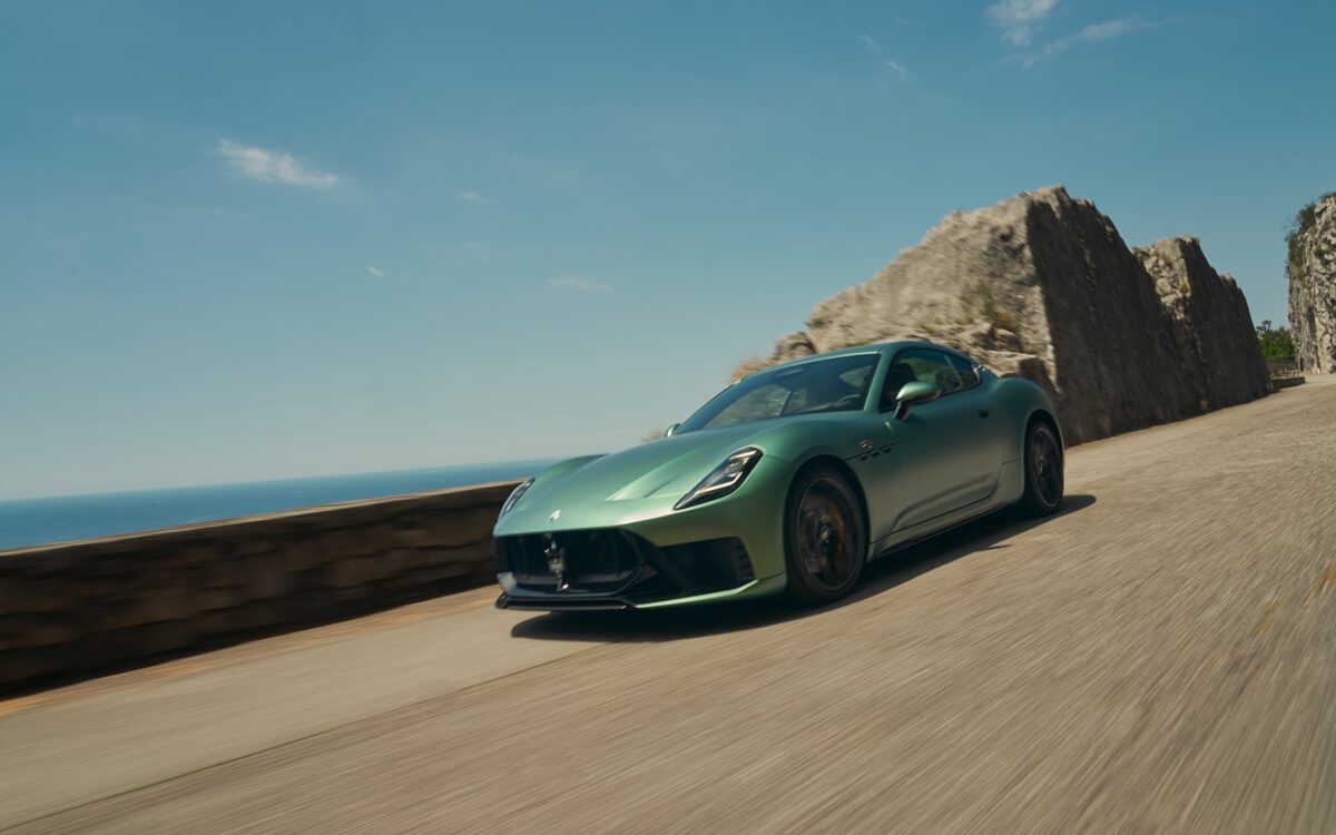 Maserati GranTurismo in pale green driving along a coastal road
