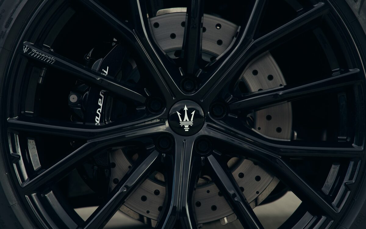 Close-up of the Grecale black alloy wheel with drilled brake disc