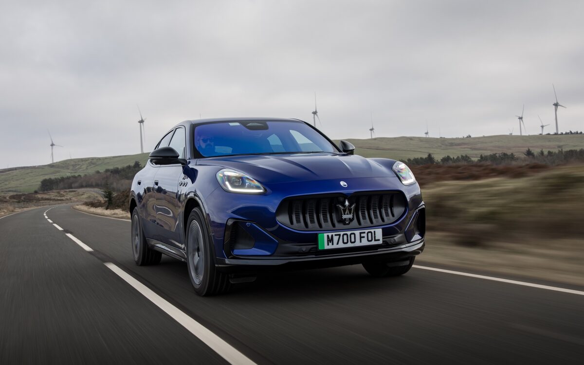 Blue Maserati Grecale Folgore driving on a country road, front three-quarter view