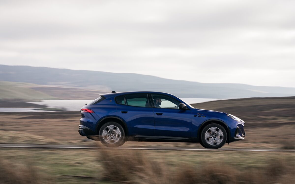 Blue Maserati Grecale Folgore in side profile on a moorland road