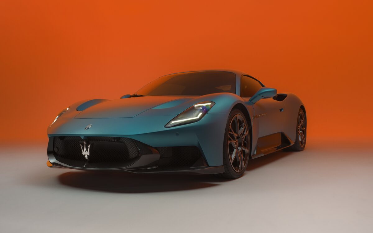 Maserati MCPURA in teal, front three-quarter view against an orange backdrop