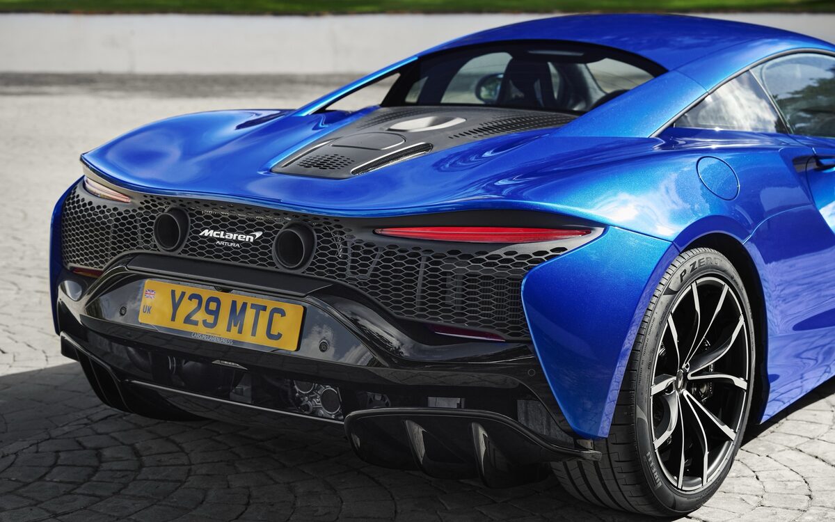 McLaren Artura in blue, close rear three-quarter view showing the engine cover and exhausts