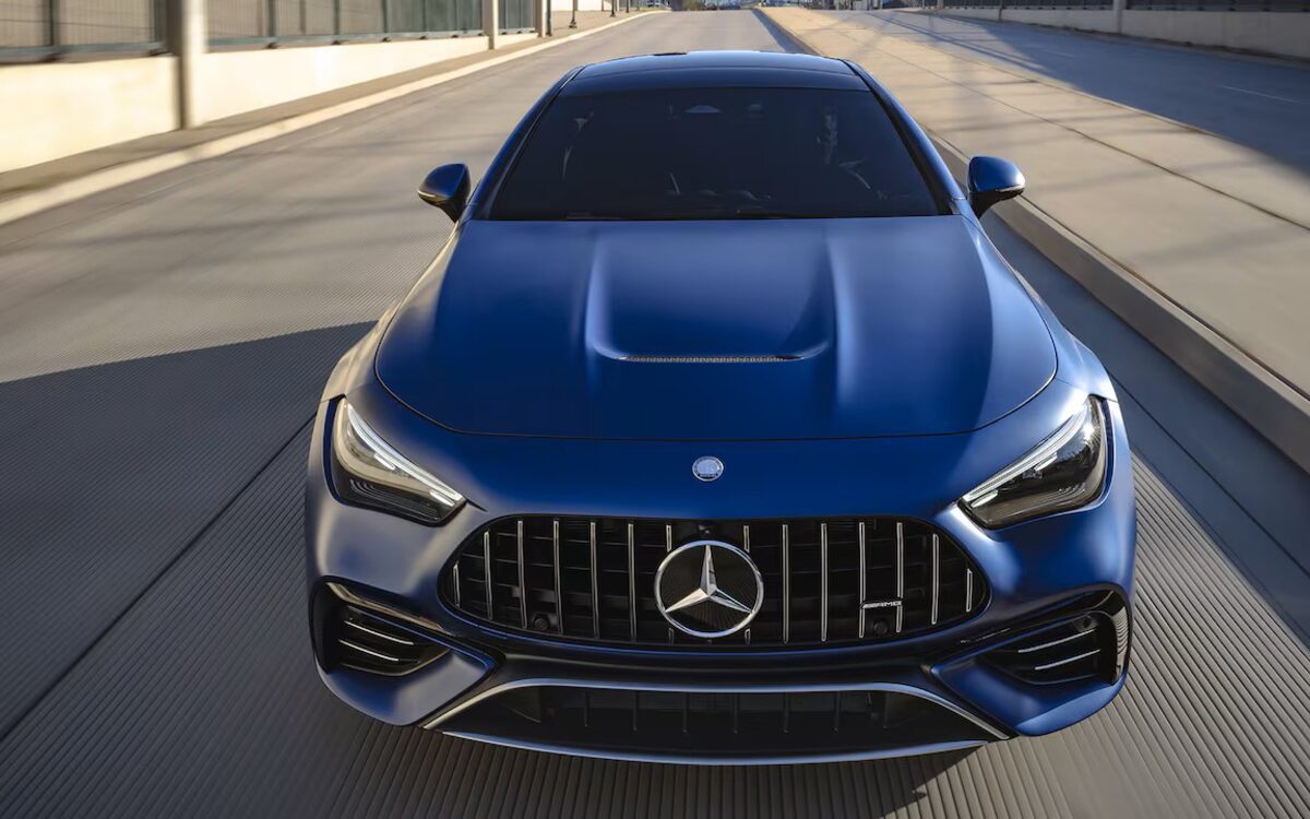 Mercedes-AMG CLE 53 Coupé in blue driving towards the camera, seen from above, with the AMG grille and power domes on the bonnet