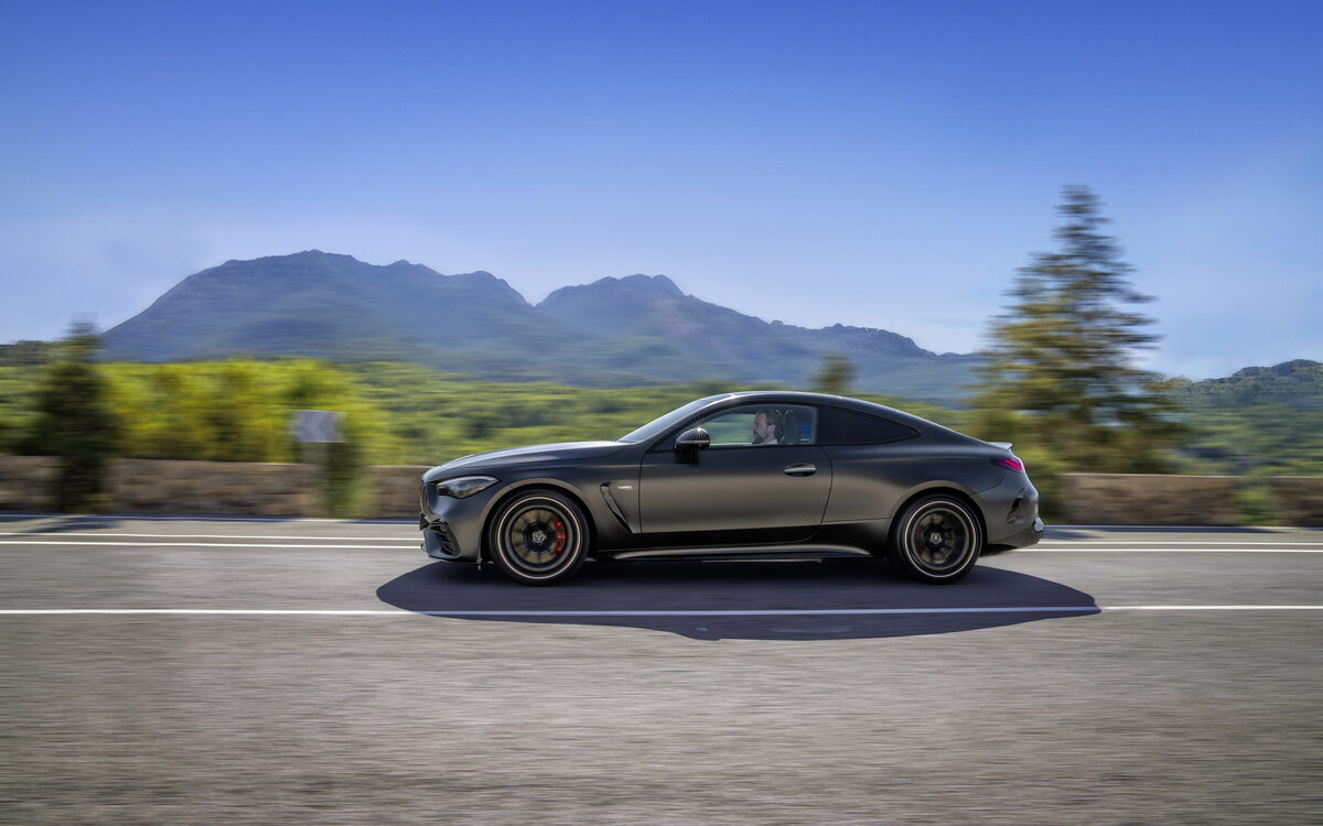 Mercedes-AMG CLE 53 Coupé in matte grey driving on a mountain road, side profile