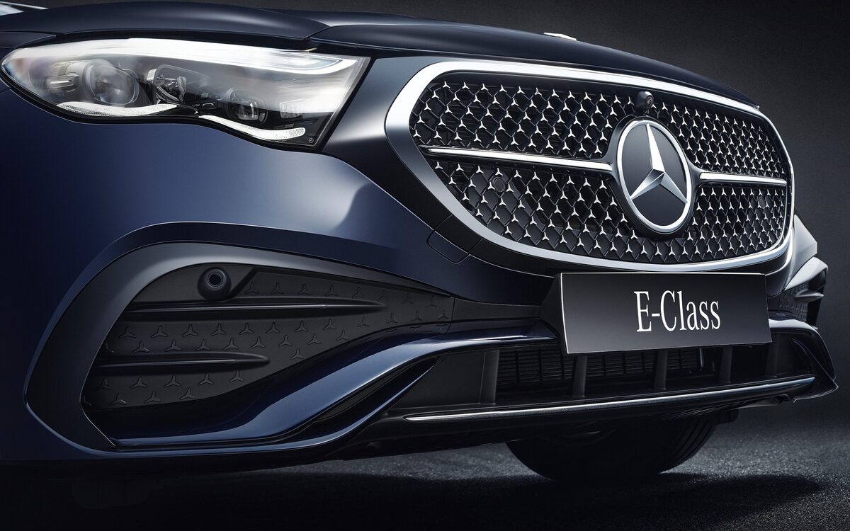 Close-up of the star-pattern grille and LED headlamp of a dark blue E-Class