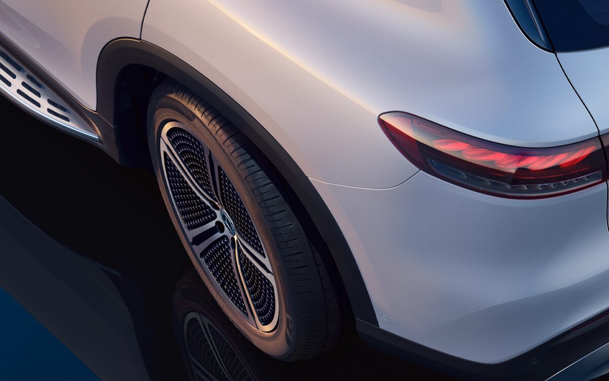 Close-up of the rear wheel, wing and tail lamp of a white EQS SUV