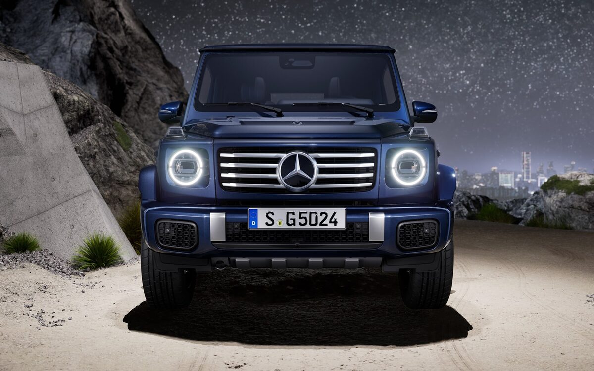 Mercedes-Benz G-Class in dark blue, front view at night with round LED headlamps on a rocky desert track