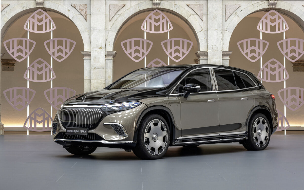 Mercedes-Maybach EQS SUV in brown and black two-tone, front three-quarter view in a stone courtyard