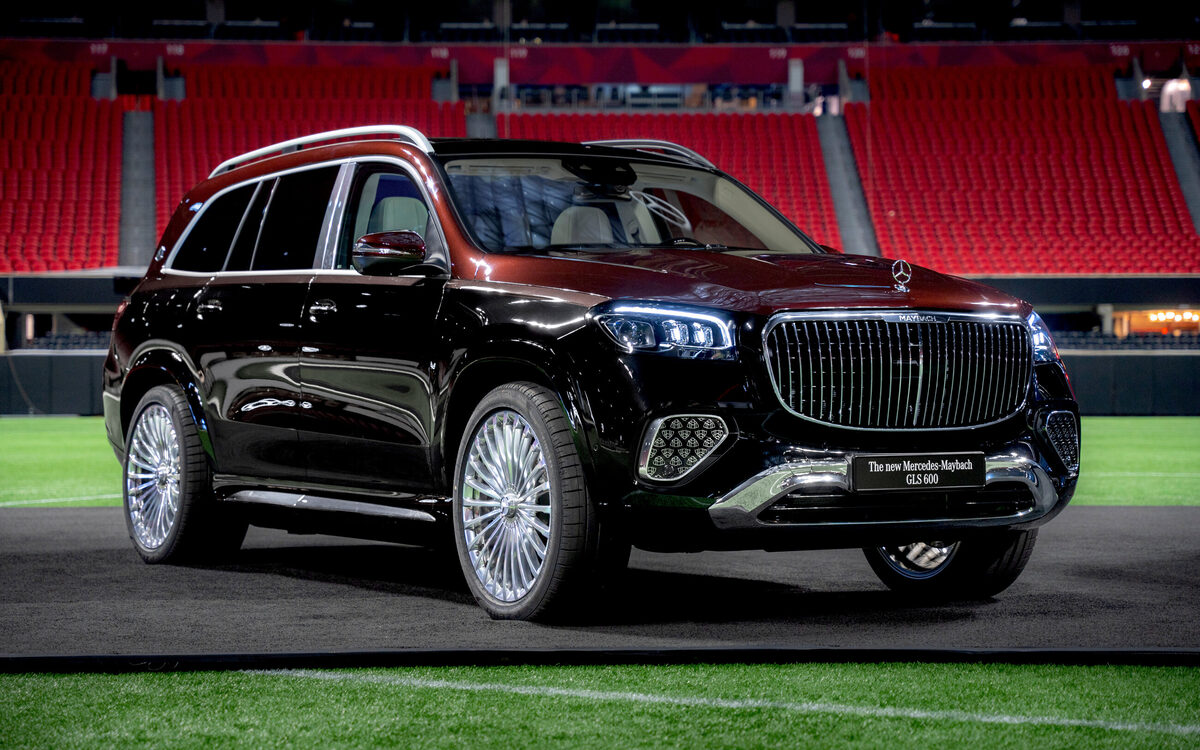 Black Mercedes-Maybach GLS front view with the vertical-slat grille, parked on a stadium pitch