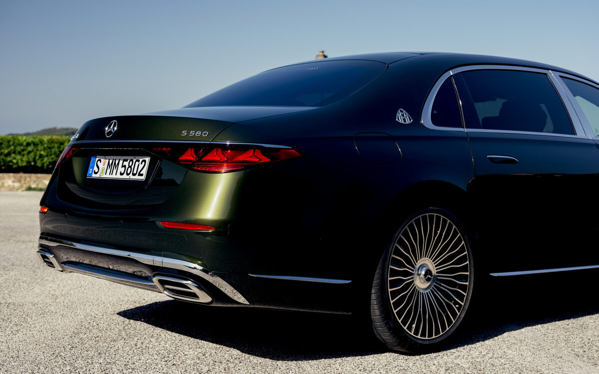 Dark green Mercedes-Maybach S-Class rear three-quarter view with tail lamps and alloy wheel