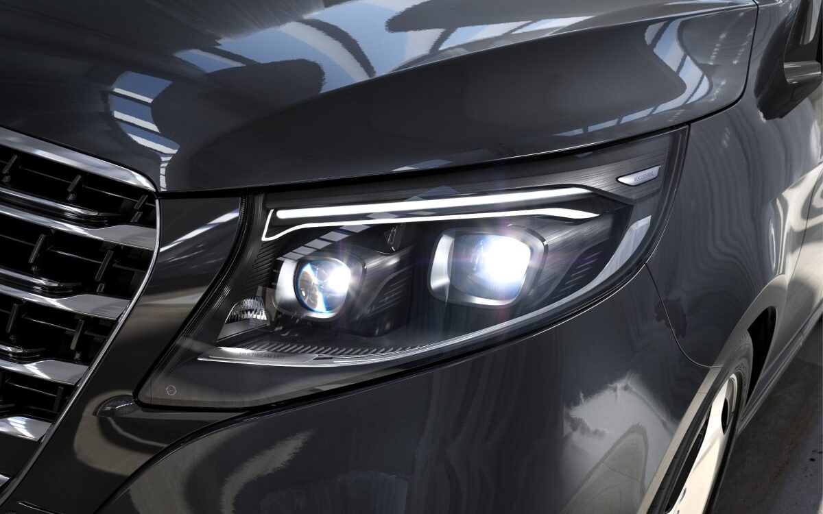 Close-up of the MULTIBEAM LED headlamp and grille corner of a dark grey V-Class