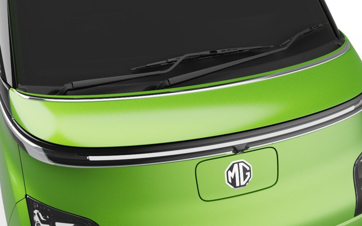 Close-up of the MG badge, hood and chrome light strip on a green MG Comet EV