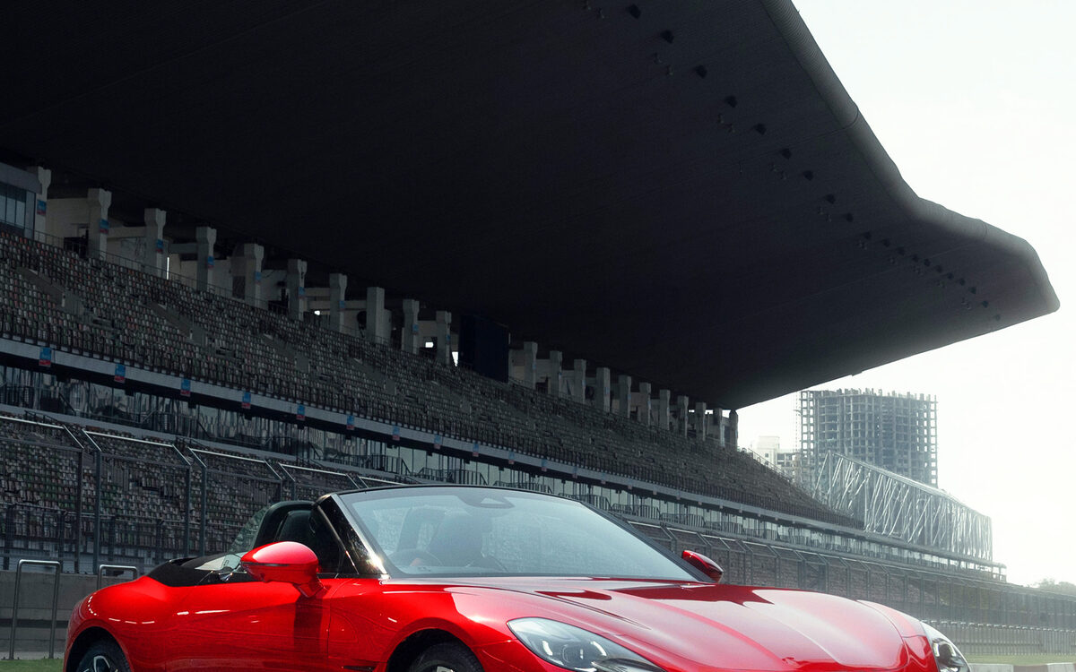 MG Cyberster in red, front three-quarter view under a grandstand roof