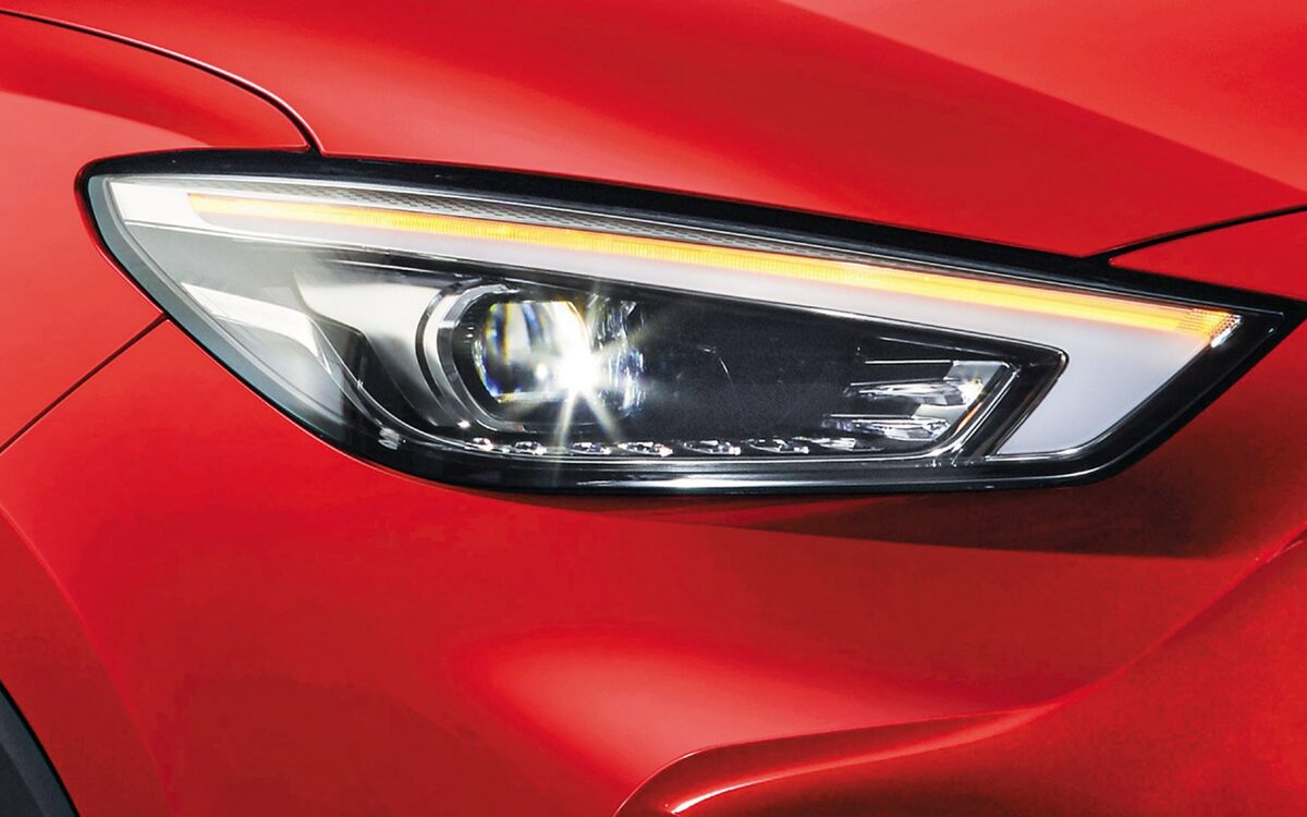 Close-up of the LED headlamp and DRL on a red MG ZS EV