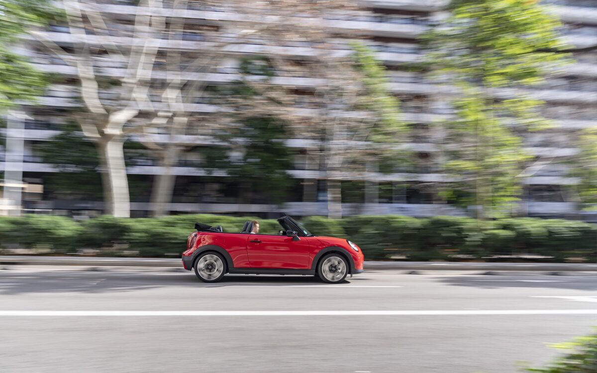 MINI Cooper Convertible S in red driving past, side profile with the roof down