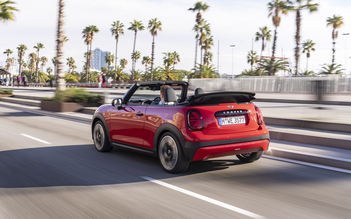 MINI Cooper Convertible S in red, rear three-quarter view on a palm-lined road