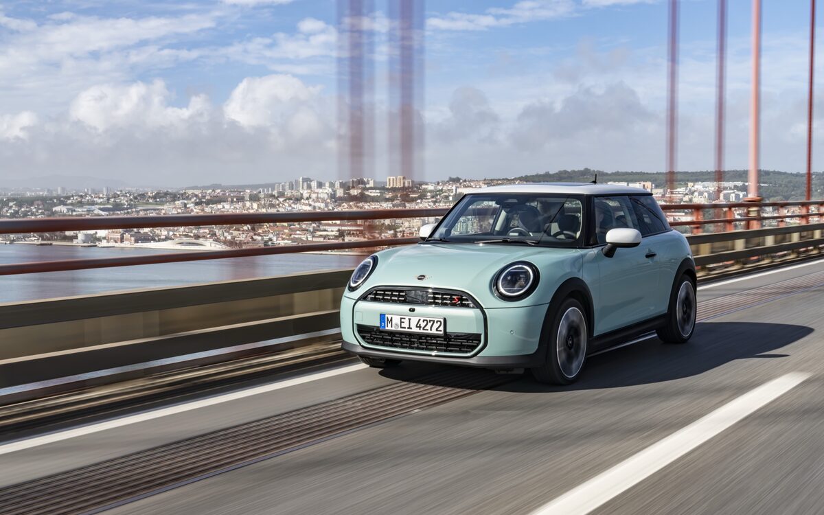 MINI Cooper S three-door in light green driving over a bridge, front three-quarter view