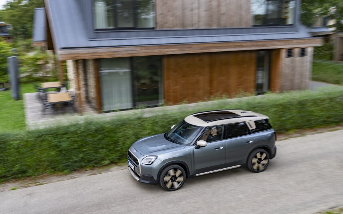 MINI Countryman in grey seen from above driving along a hedge-lined lane