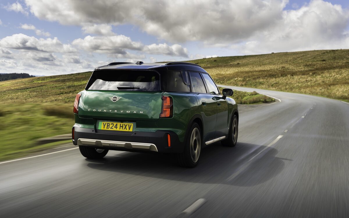 MINI Countryman Electric in green, rear three-quarter view on a road