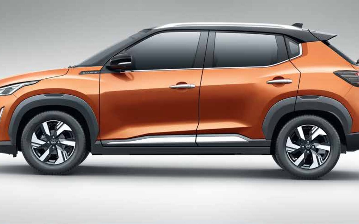 Nissan Magnite in orange with a black roof, side profile on a light studio background