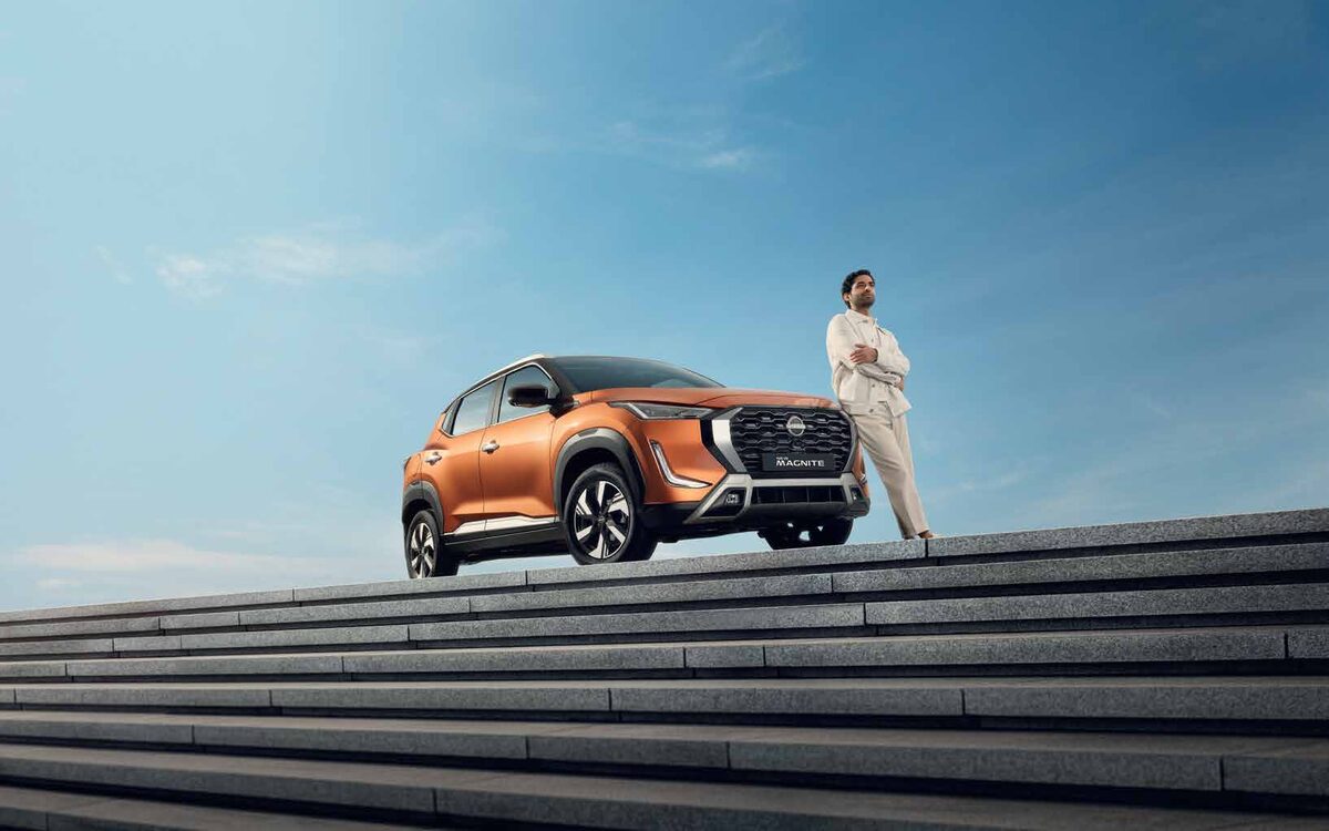 Nissan Magnite parked at the top of stone steps with a man standing beside it